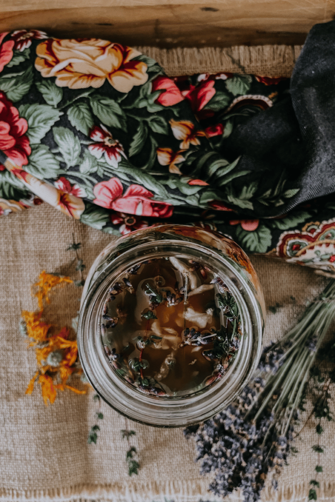 mason jar filled with fire cider on table with lavender on the side