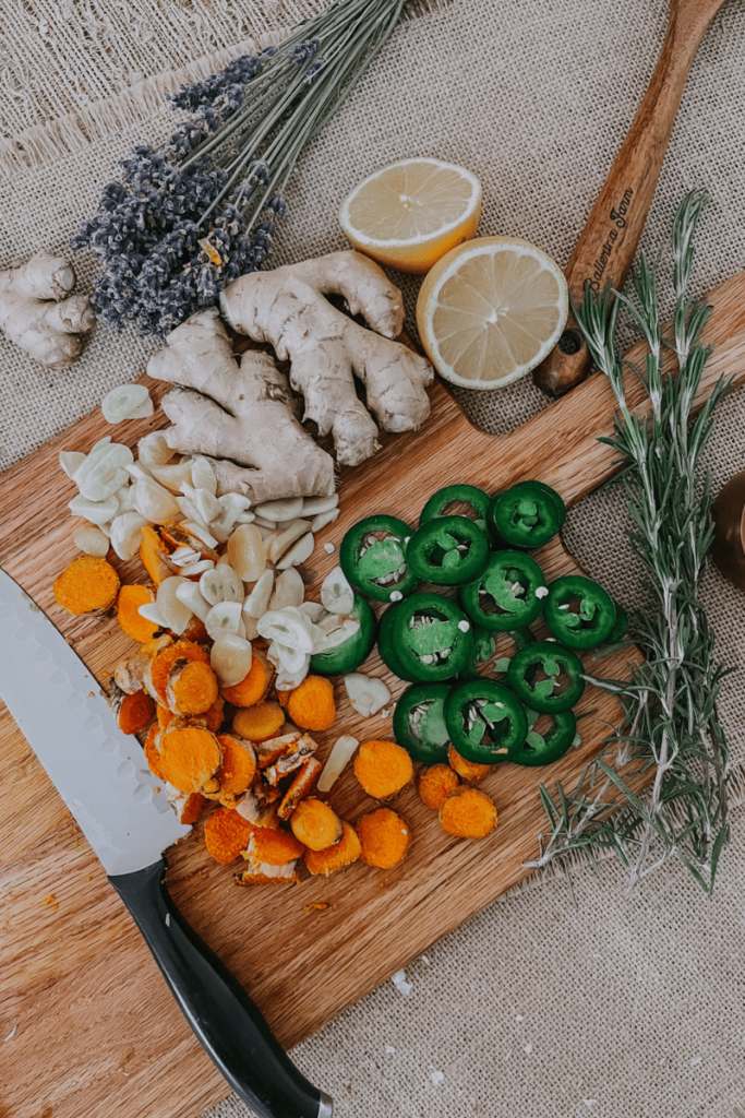 carrots, jalapeños, garlic, ginger and lemon on wood cutting board