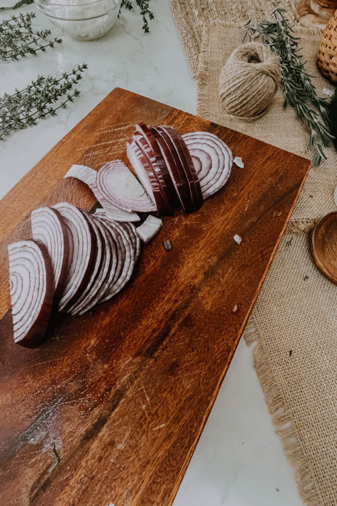 sliced red onion on a wooden cutting board