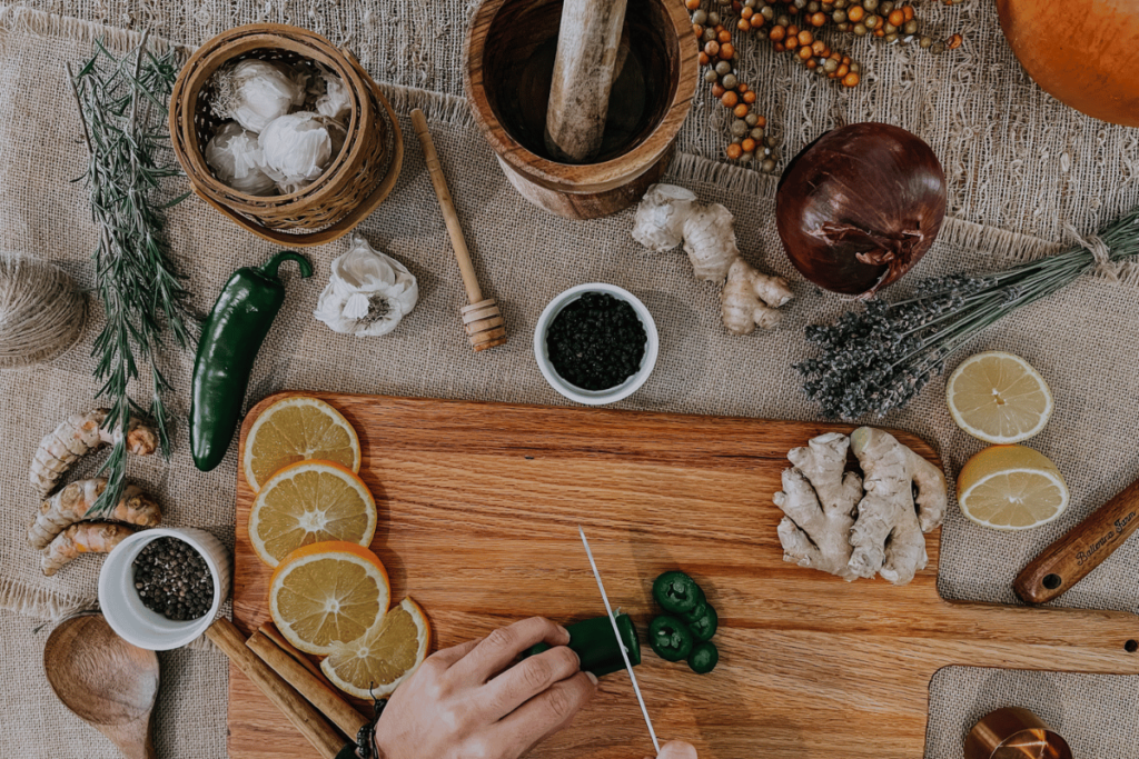 dicing jalapeños on a wooden cutting board to make fire cider